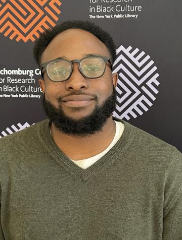 A man wearing glasses and a green sweater